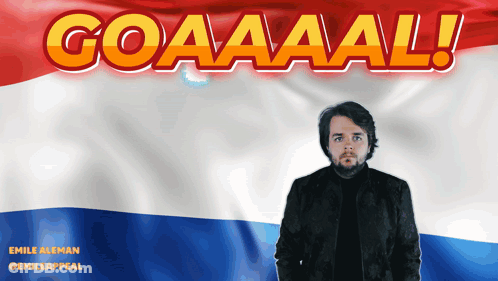 A Man Is Standing In Front Of A Flag That Says Goaaaal GIF