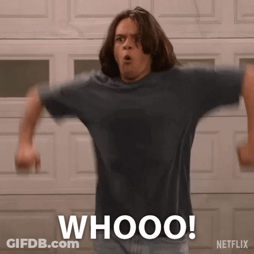 A Man Is Standing In Front Of A Garage Door With His Arms Outstretched And The Words Whooo Written On His Shirt . GIF