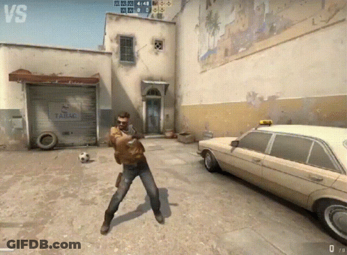 A Man Is Standing In Front Of A Garage That Says Tabac On It GIF