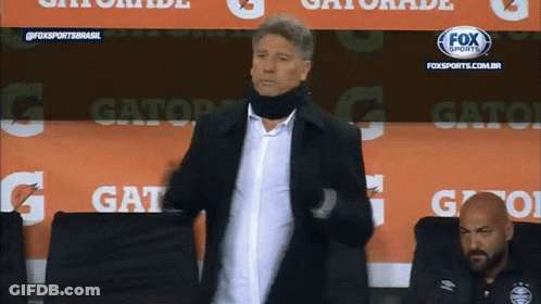A Man Is Standing In Front Of A Gatorade Advertisement GIF
