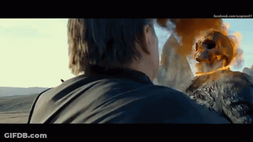 A Man Is Standing In Front Of A Ghost Rider With A Skull On It 'S Head GIF