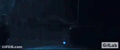 A Man Is Standing In Front Of A Giant Monster In A Dark Room With A Giflab Logo In The Corner GIF