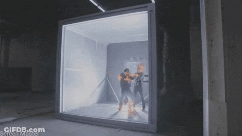 A Man Is Standing In Front Of A Glass Box That Says Screen Master On It GIF