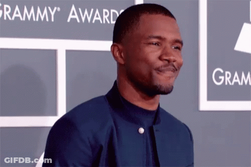 A Man Is Standing In Front Of A Grammy Award Sign GIF