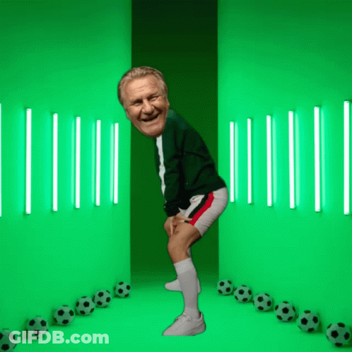 A Man Is Standing In Front Of A Green Wall With Soccer Balls GIF