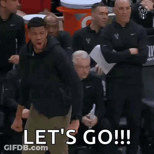 A Man Is Standing In Front Of A Group Of Men And Shouting Let 'S Go . GIF