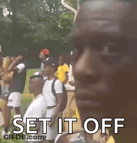 A Man Is Standing In Front Of A Group Of People And Says `` Set It Off '' GIF