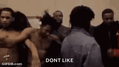 A Man Is Standing In Front Of A Group Of People Without Shirts . GIF