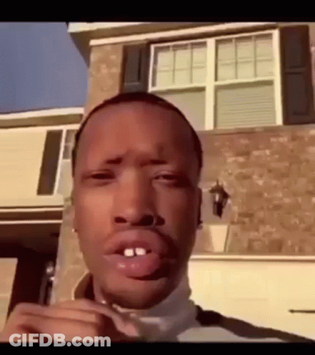 A Man Is Standing In Front Of A House With His Mouth Open . GIF