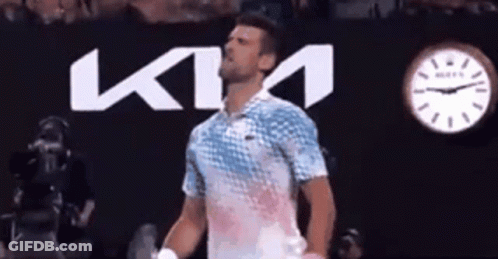 A Man Is Standing In Front Of A Ktm Logo GIF