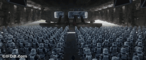 A Man Is Standing In Front Of A Large Group Of Stormtroopers GIF