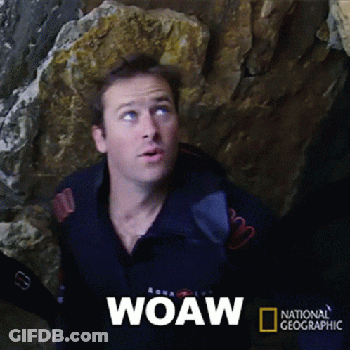 A Man Is Standing In Front Of A Large Rock And The Word Woaw Is On The Screen GIF