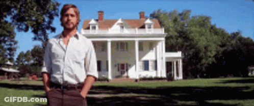 A Man Is Standing In Front Of A Large White House GIF