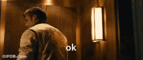 A Man Is Standing In Front Of A Light And Says Ok GIF