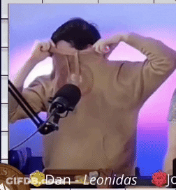 A Man Is Standing In Front Of A Microphone And The Name Dan Leonidas Is On The Bottom Right GIF