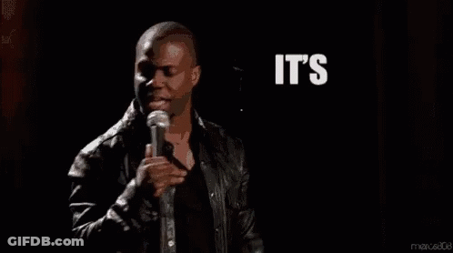 A Man Is Standing In Front Of A Microphone With The Words `` It 'S About To Go Down '' Written In White Letters . GIF