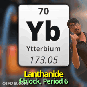 A Man Is Standing In Front Of A Periodic Table Of Ytterbium GIF