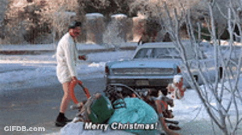A Man Is Standing In Front Of A Pile Of Garbage And Says Merry Christmas GIF