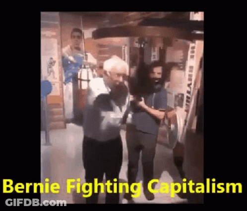 A Man Is Standing In Front Of A Punching Bag With The Words `` Bernie Fighting Capitalism '' . GIF