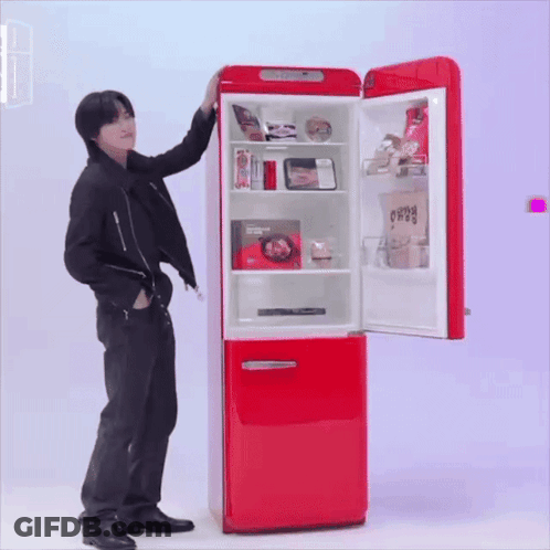 A Man Is Standing In Front Of A Red Refrigerator That Has The Door Open GIF
