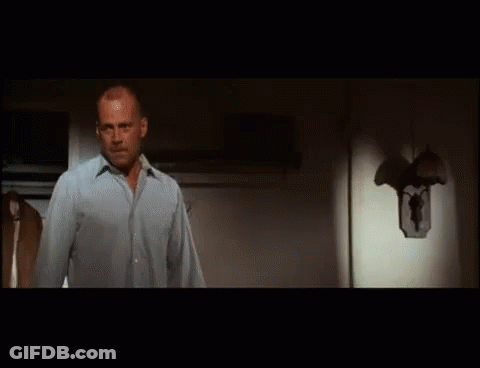 A Man Is Standing In Front Of A Refrigerator Door . GIF