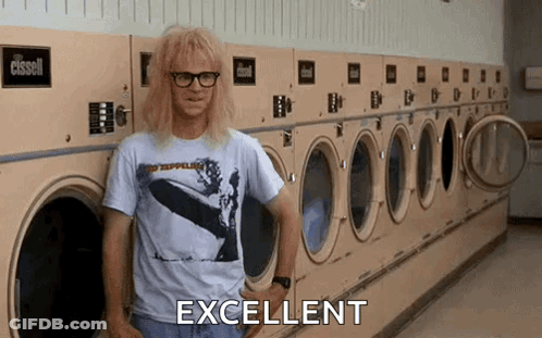 A Man Is Standing In Front Of A Row Of Washing Machines In A Laundromat And Says Excellent . GIF