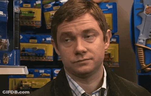 A Man Is Standing In Front Of A Shelf Full Of Toy Trains GIF