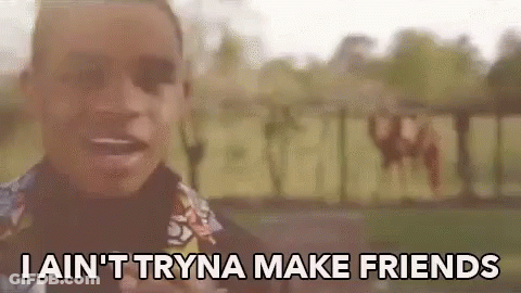 A Man Is Standing In Front Of A Sign That Says I Ain 'T Tryna Make Friends GIF