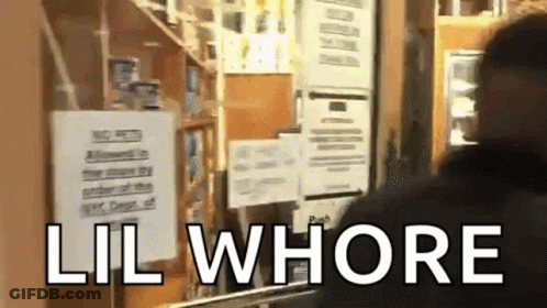 A Man Is Standing In Front Of A Sign That Says Lil Whore GIF