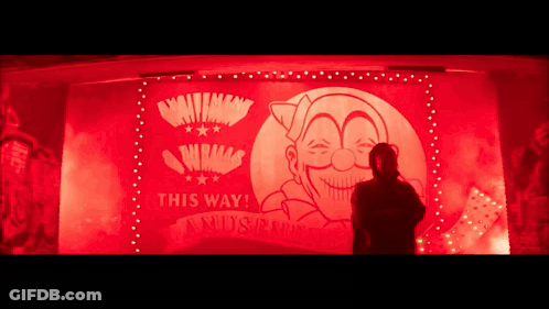 A Man Is Standing In Front Of A Sign That Says This Way ! GIF