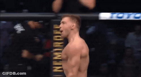 A Man Is Standing In Front Of A Sign That Says ' Ufc ' On It . GIF