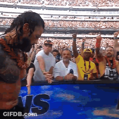 A Man Is Standing In Front Of A Sign That Says Us GIF