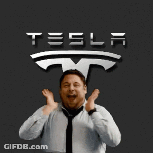 A Man Is Standing In Front Of A Tesla Sign GIF