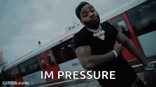 A Man Is Standing In Front Of A Train With His Arms Crossed And The Words `` Im Pressure '' Written On The Screen . GIF