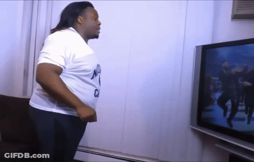 A Man Is Standing In Front Of A Tv And Wearing A White Shirt That Says Nyc GIF