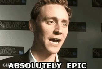 A Man Is Standing In Front Of A Wall That Says Absolutely Epic GIF