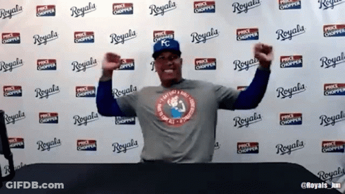 A Man Is Standing In Front Of A Wall That Says Royals GIF
