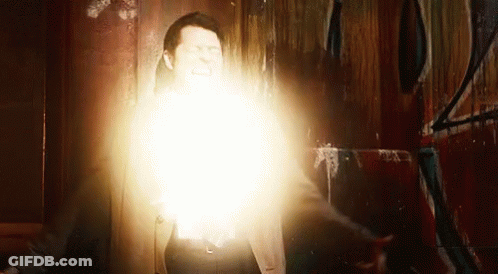 A Man Is Standing In Front Of A Wall With A Light Coming Out Of His Chest . GIF