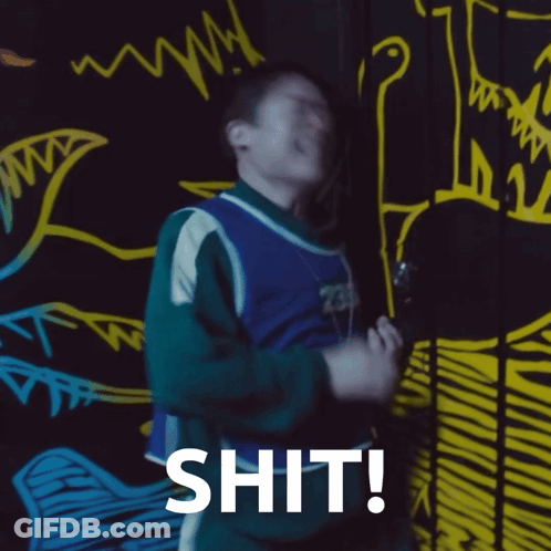 A Man Is Standing In Front Of A Wall With Drawings On It And The Word Shit Written On It GIF