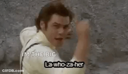 A Man Is Standing In Front Of A Wall With His Fist In The Air And Says `` I 'M The Big '' . GIF