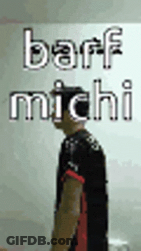 A Man Is Standing In Front Of A Wall With The Words Barf Michi On It . GIF