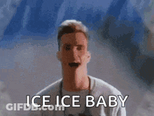 A Man Is Standing In Front Of A Wall With The Words Ice Ice Baby On It . GIF