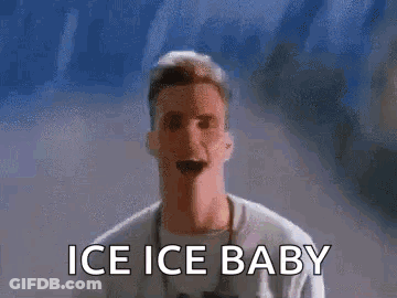 A Man Is Standing In Front Of A Wall With The Words `` Ice Ice Baby '' On It . GIF