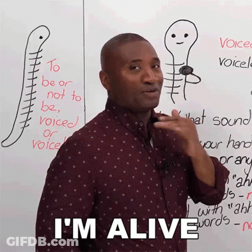 A Man Is Standing In Front Of A White Board With A Drawing Of A Skeleton And The Words I 'M Alive GIF