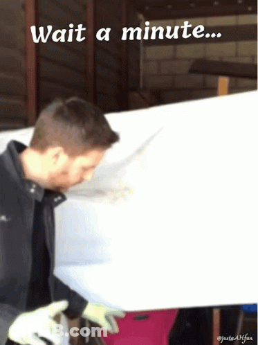 A Man Is Standing In Front Of A White Board With The Words Wait A Minute Below Him GIF