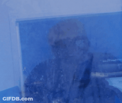 A Man Is Standing In Front Of A Window That Says Powered On It GIF