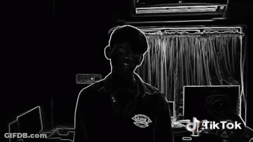 A Man Is Standing In Front Of A Window With A Tiktok Logo On The Bottom Right GIF