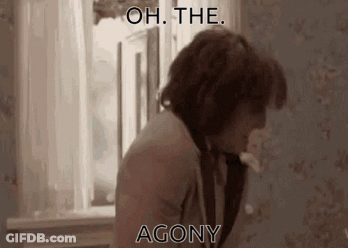 A Man Is Standing In Front Of A Window With The Words " Oh The Agony " Written On The Screen . GIF