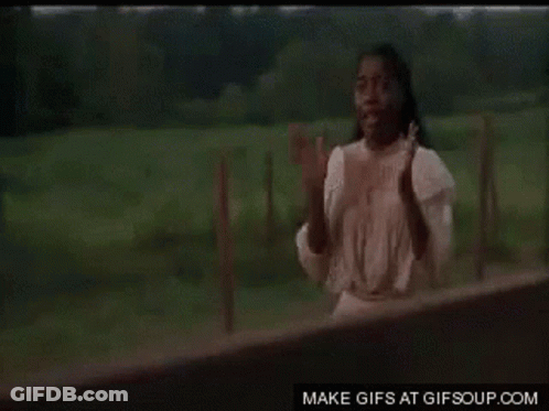 A Man Is Standing In Front Of A Wooden Fence . GIF