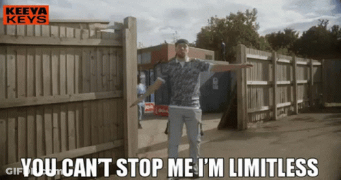 A Man Is Standing In Front Of A Wooden Fence With The Words " You Can 'T Stop Me I 'M Limitless " GIF
